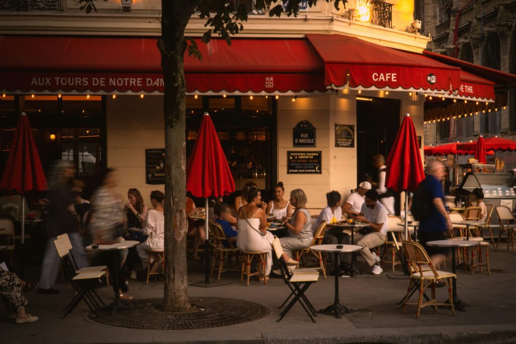 Café em Paris com mesas externas e atmosfera elegante, ideal para ilustrar bleisure e viagens corporativas