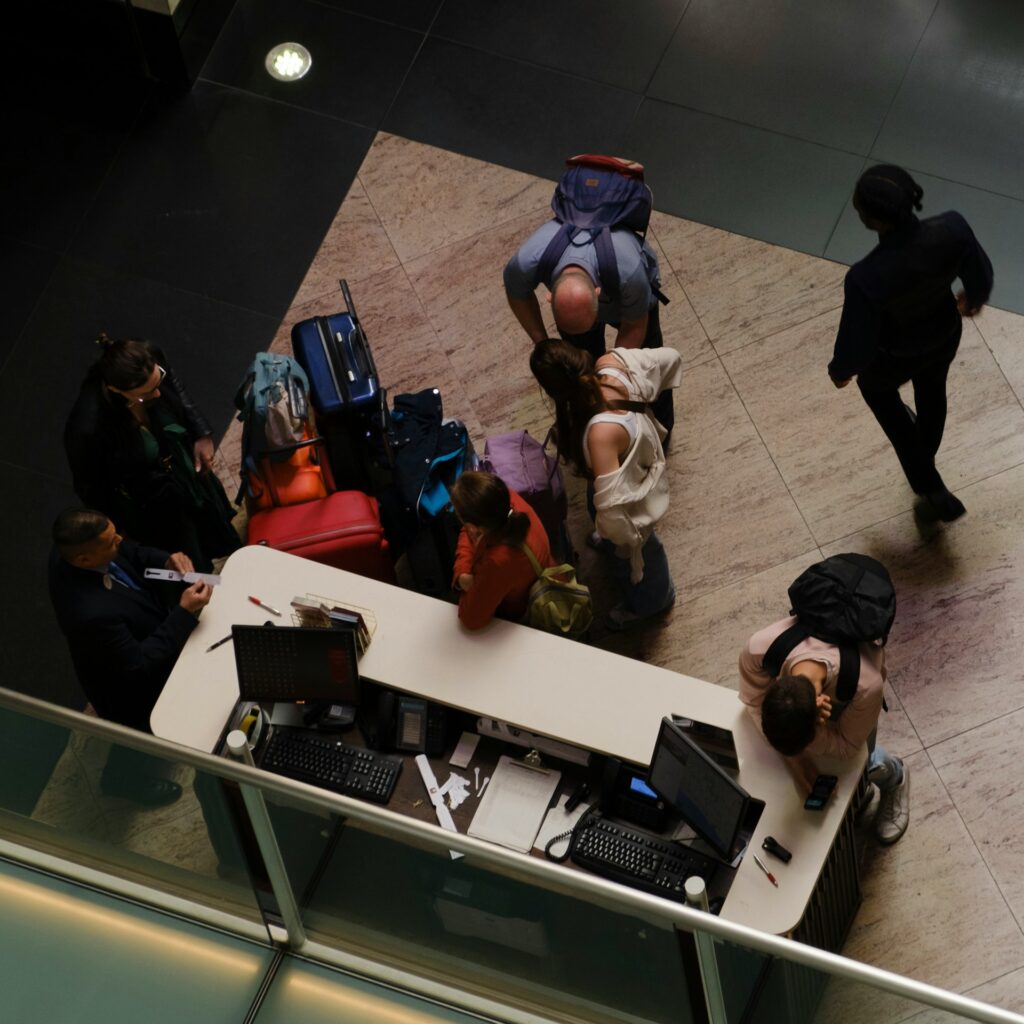 Vista superior de recepção com hóspedes e equipe, representando logística de chegada, hospitalidade e assessoria de viagem exclusiva