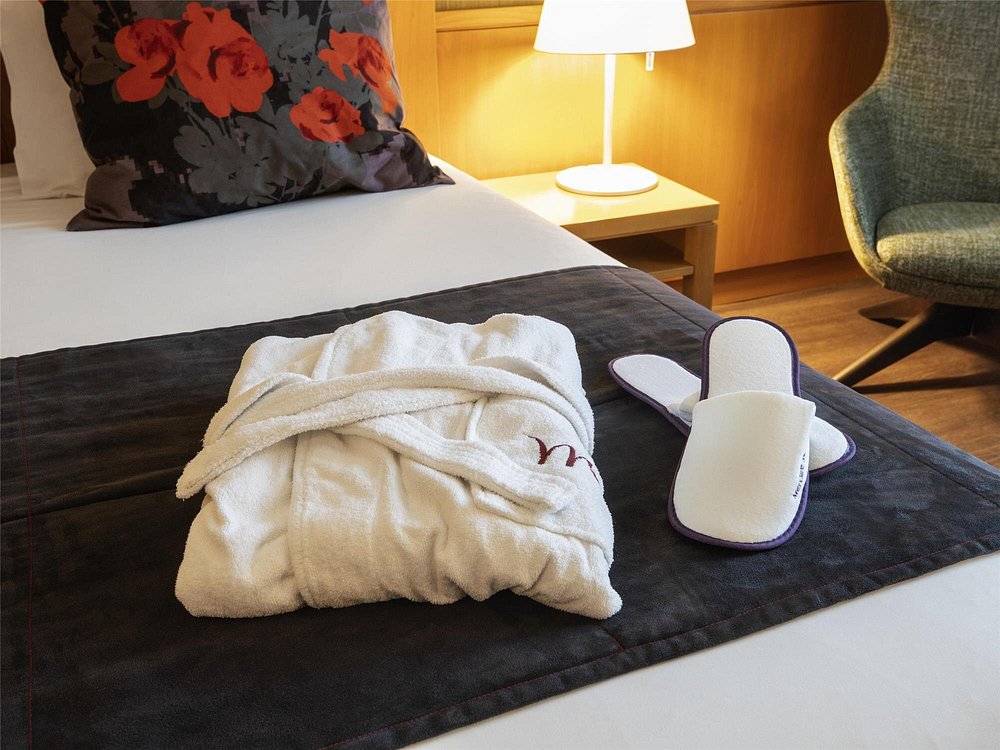Cama com roupão e amenidades em quarto do Mercure Porto Gaia Hotel